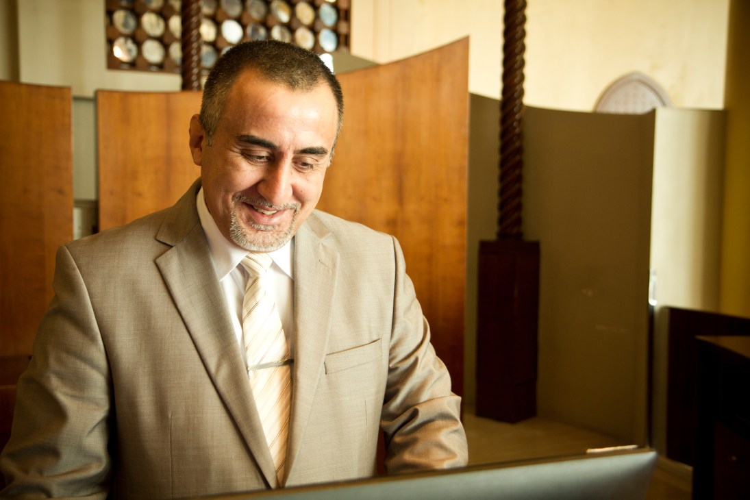 Front-office manager Hisham at the Corinthia Hotel in Tripoli standing at the front desk.