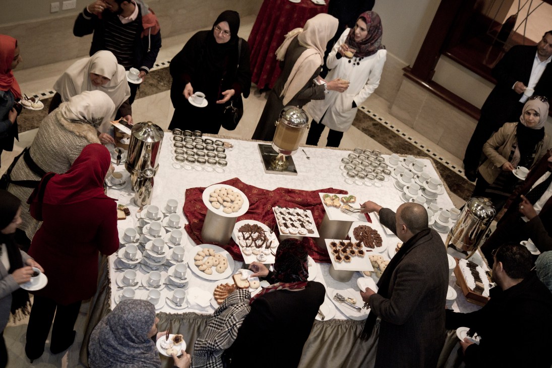 Workshop participants gather around a table with desserts and beverages at the Corinthia Hotel.