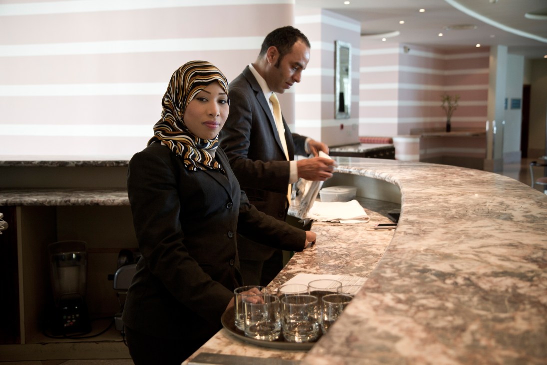 Hotel staff member and manager at front desk in Tripoli's Corinthia Hotel