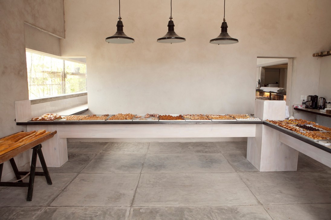 Interior of La Linda restaurant displaying baked goods on white counters under pendant lighting.