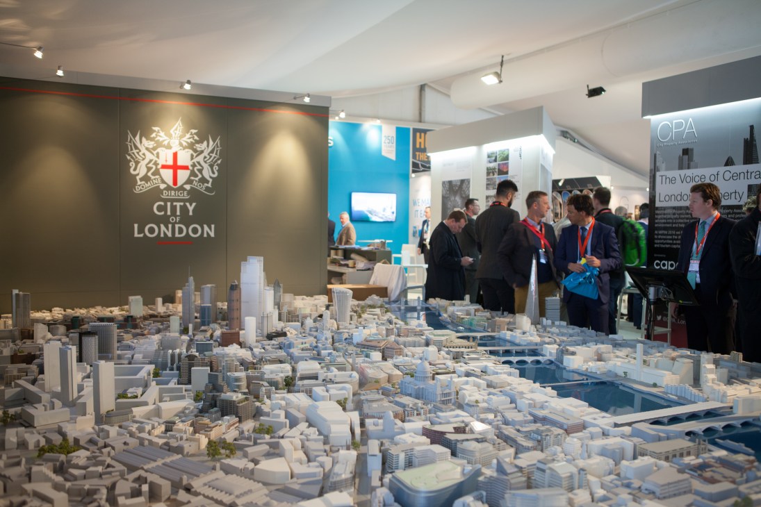 London's stand at Mipim displays a detailed white architectural model of the city with visitors observing the display.