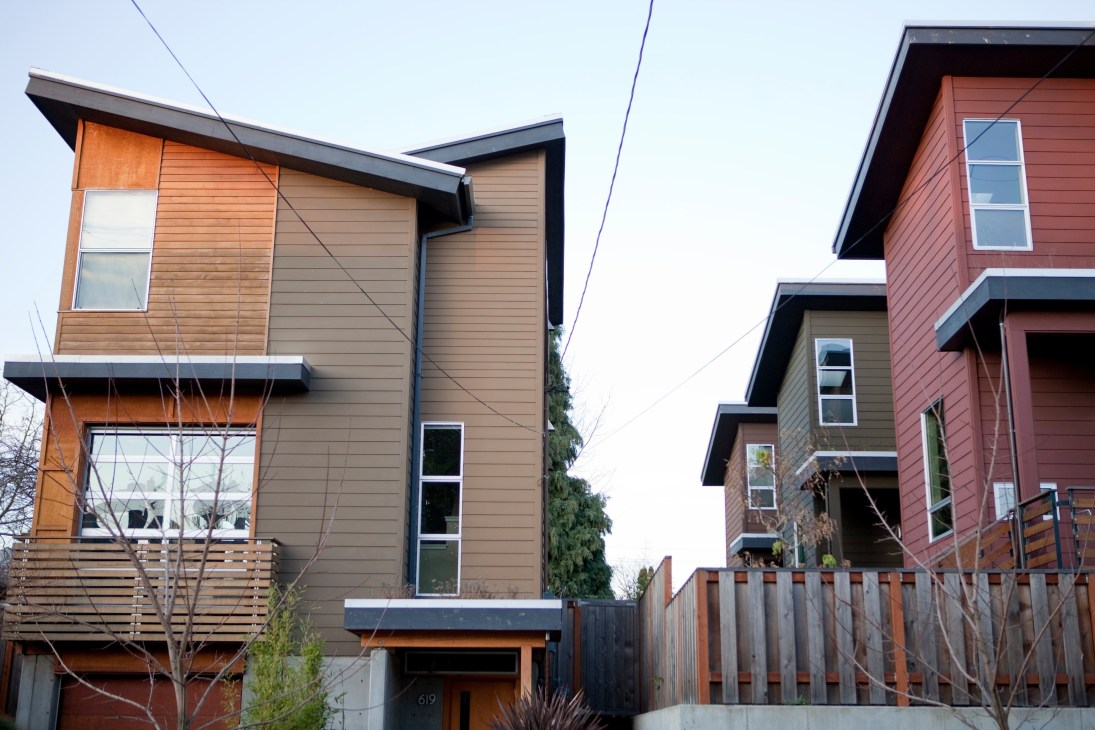 Modern residential houses with mixed wood and metal cladding on a North Portland street.