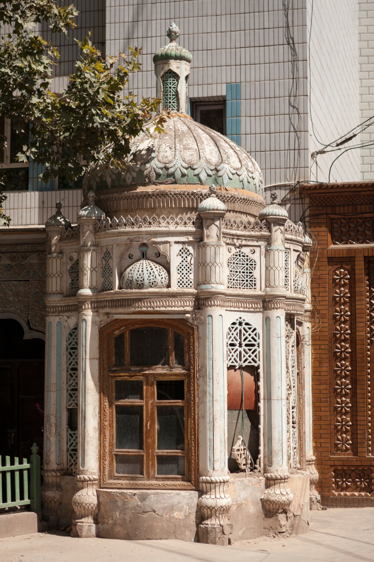 Traditional ornate Uyghur kiosk with domed roof and carved stone details in Kashgar's old town.
