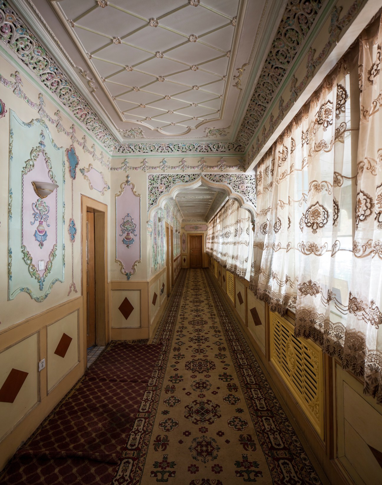 Ornate hallway with decorative painted walls and patterned carpet at Seman Hotel.