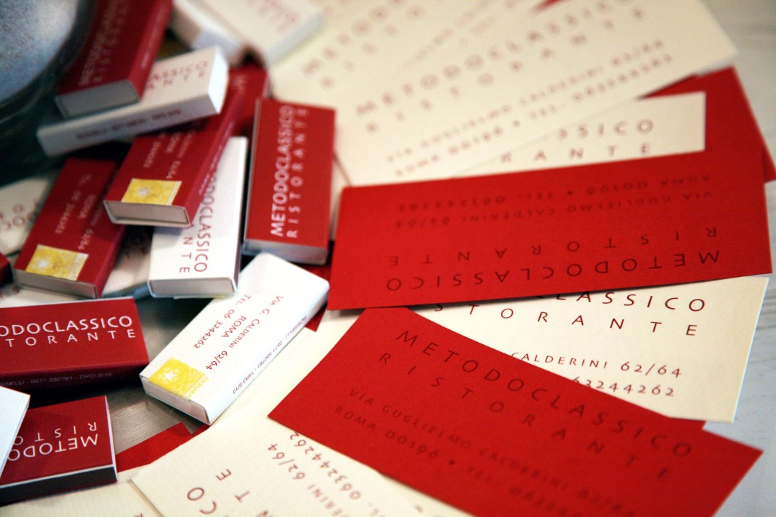 Business cards and matchbooks for Metodo Classico restaurant in red and cream colors.