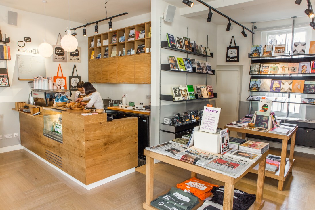 Interior of Kioskafé newsstand with wooden counter, magazines, and shelving displays