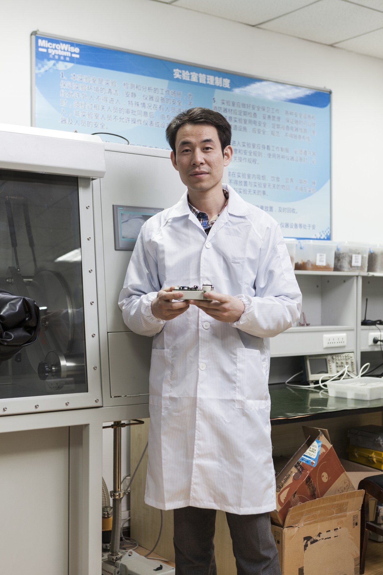 Liu Tao, a Microwise Systems engineer, holds equipment in a laboratory at the Xi'an Hi-Tech Development Zone.