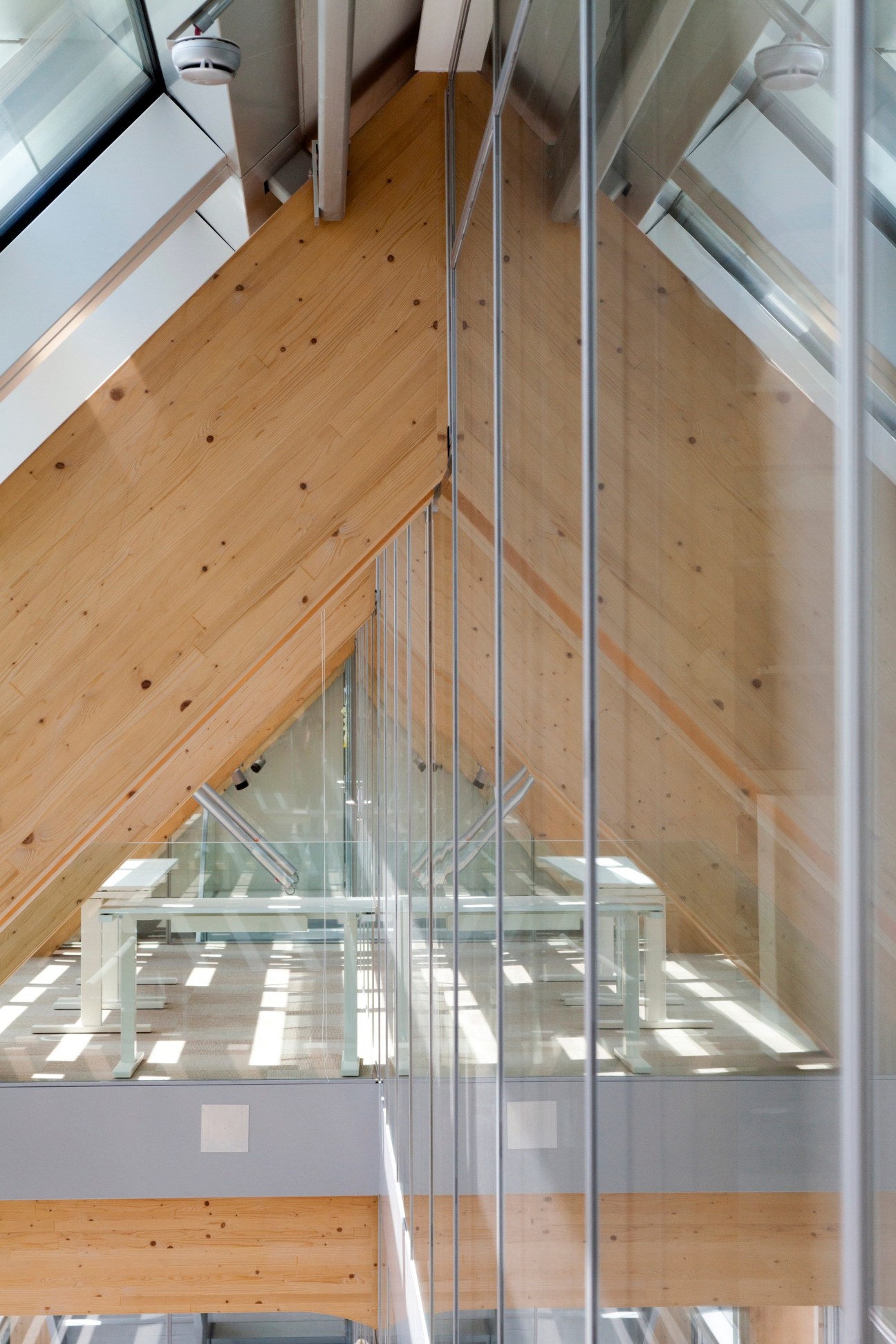 Interior view of wooden structural beams and glass railing on the seventh floor of Tamedia's new office building designed by Shigeru Ban.