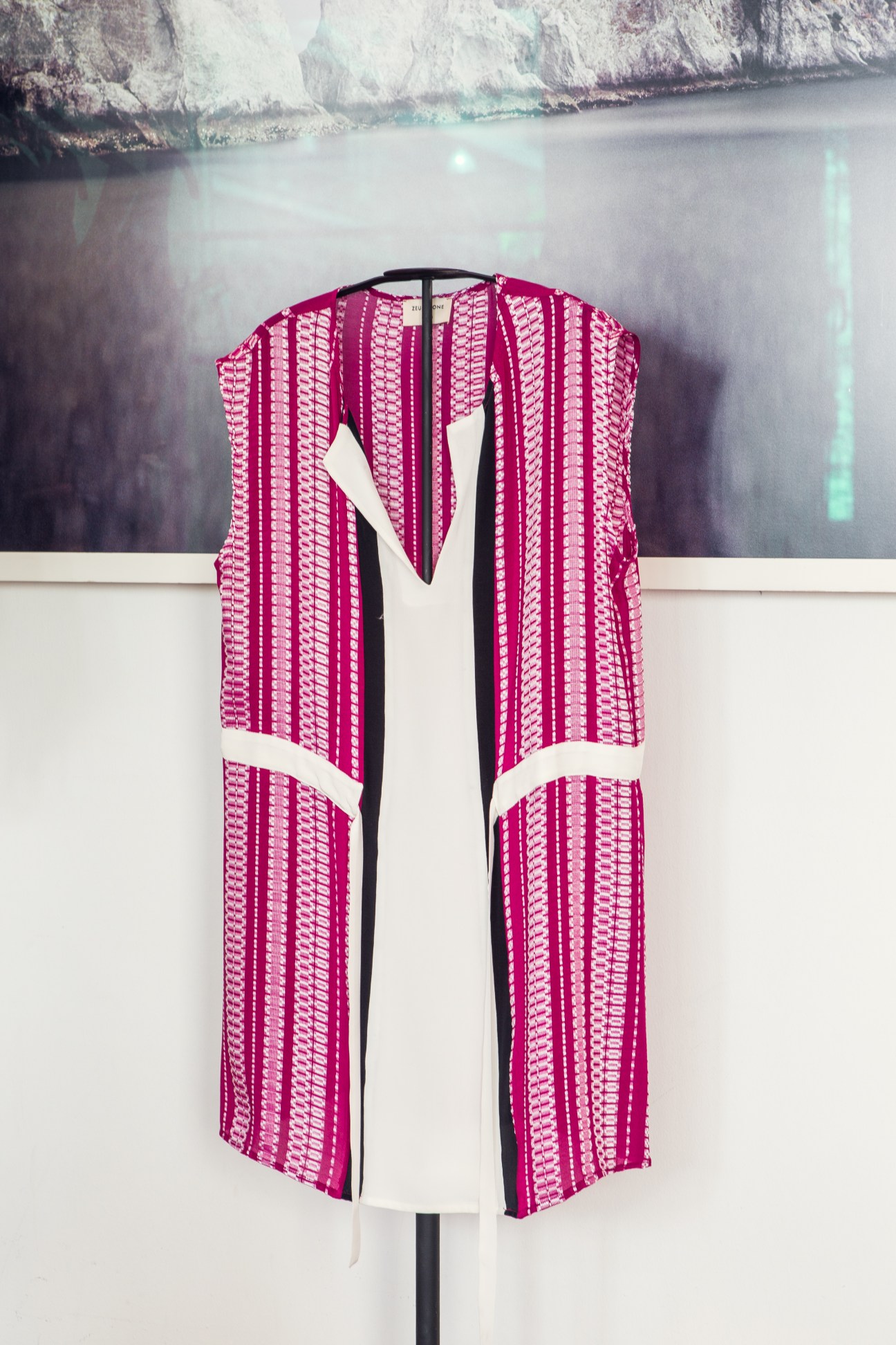 Sleeveless dress with magenta and cream geometric pattern displayed on mannequin
