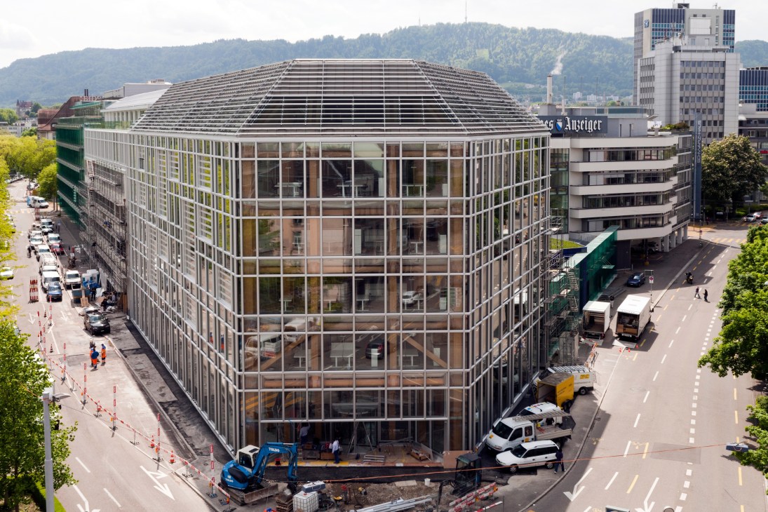 Aerial view of Tamedia's seven-storey wooden office building in Zürich designed by Shigeru Ban, showing timber structural skeleton and gridded facade.