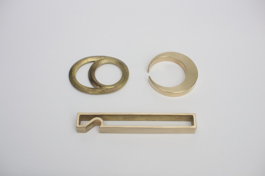 Three brass bottle-openers by Masanori Oji in different finishes and designs displayed against white background.