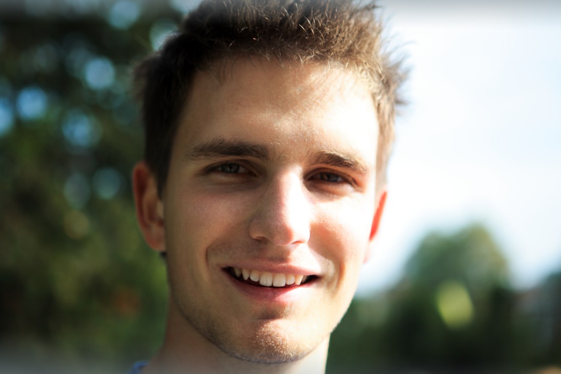 Primož Pipan, a 20-year-old student from Škofja Loka, smiling outdoors with blurred greenery in background.