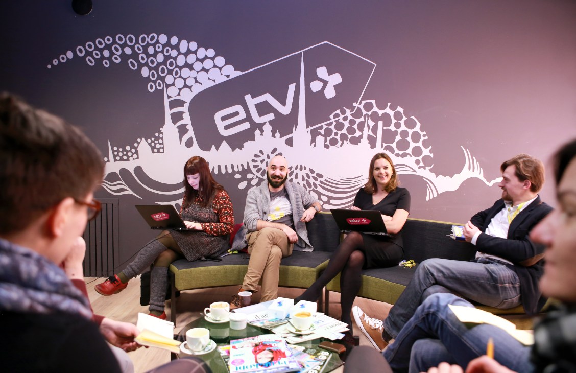 Darja Saar leads a story meeting with ETV+ programme editors around a table with the ETV+ logo visible on the wall behind them.