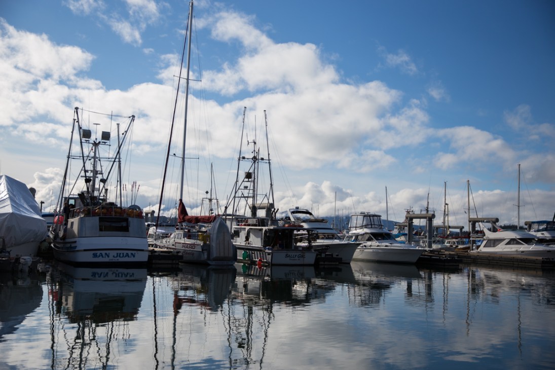 Commercial fishing boats moored at Auke Bay Harbour in Juneau, Alaska on a calm day.