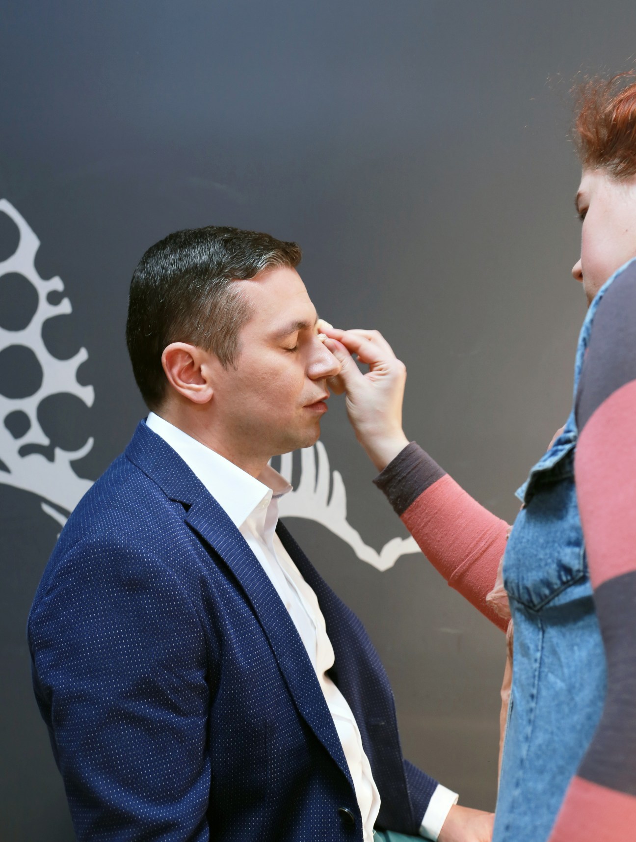 Andrei Titov, presenter of 'Your Evening', has make-up applied by a stylist.