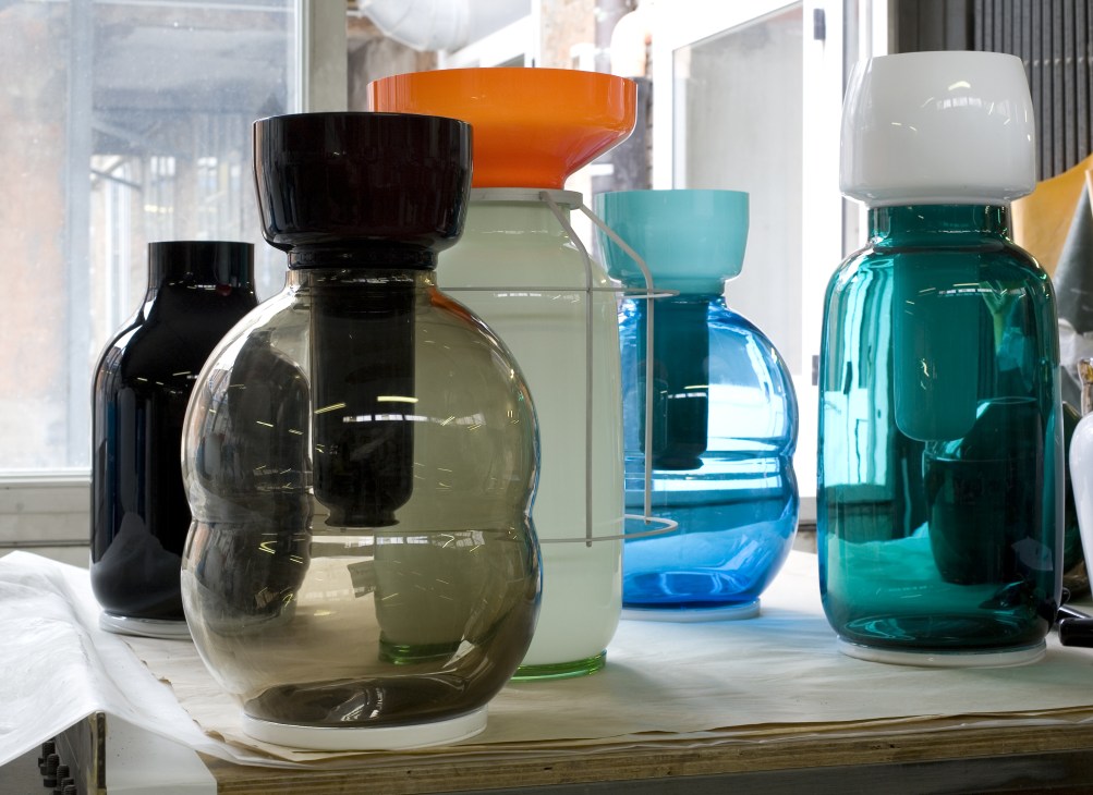 Hand-blown Murano glass vases in various colors displayed on a windowsill