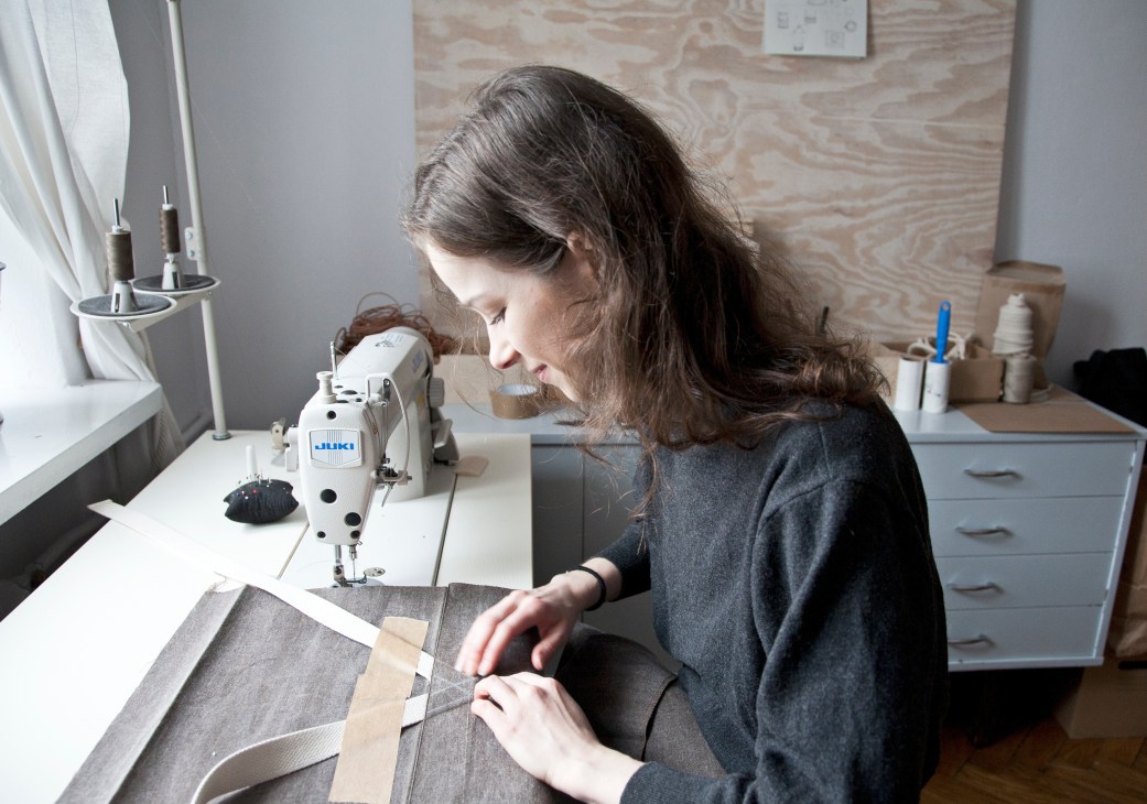 Woman sewing fabric on a JUKI sewing machine at Thisispaper studio in Warsaw.