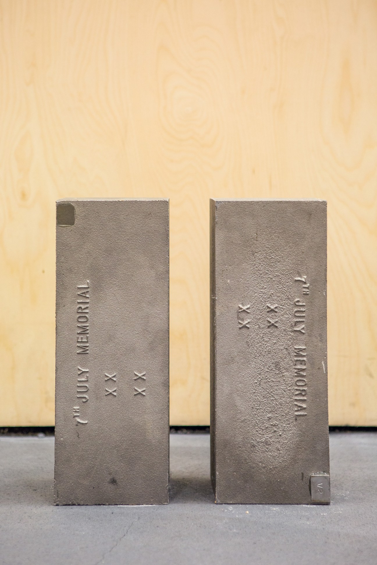 Two stainless steel rectangular models with embossed text showing date and location details from the London bombing memorial design.
