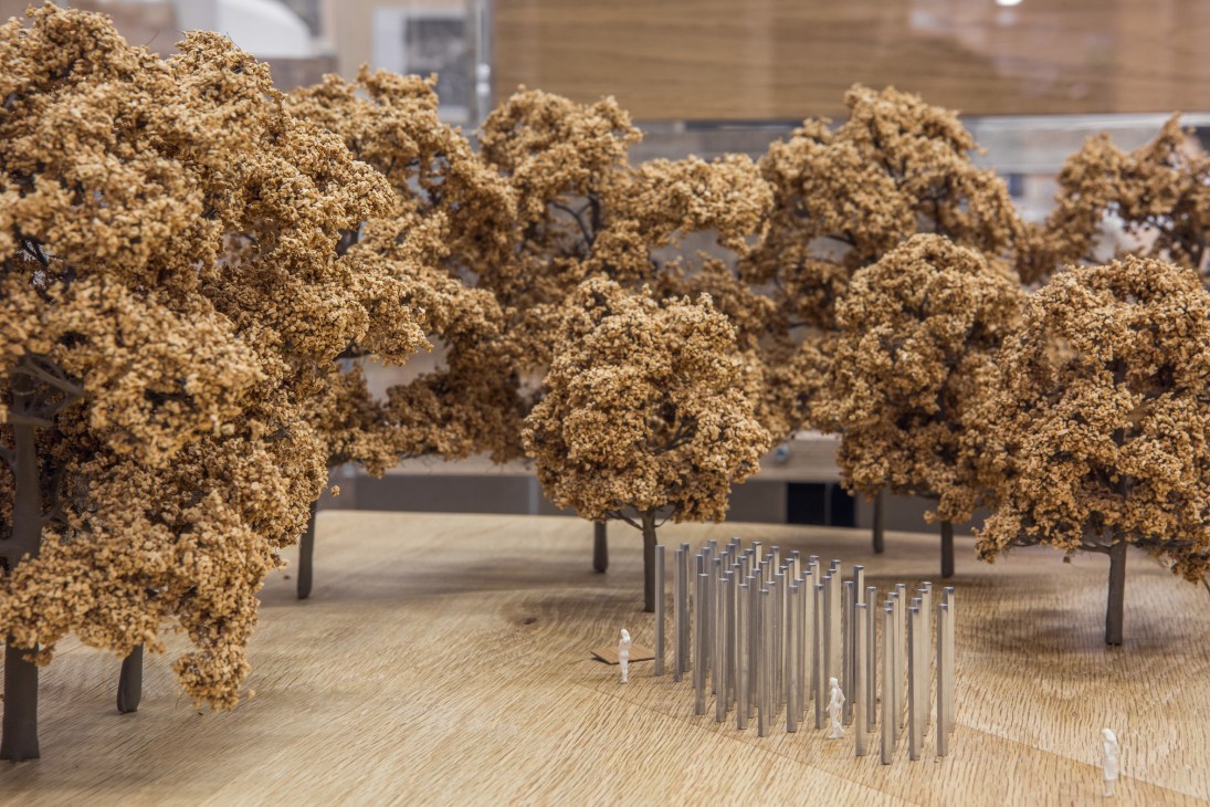 Architectural model of Carmody Groarke's Hyde Park memorial featuring miniature trees and stainless steel stelae.