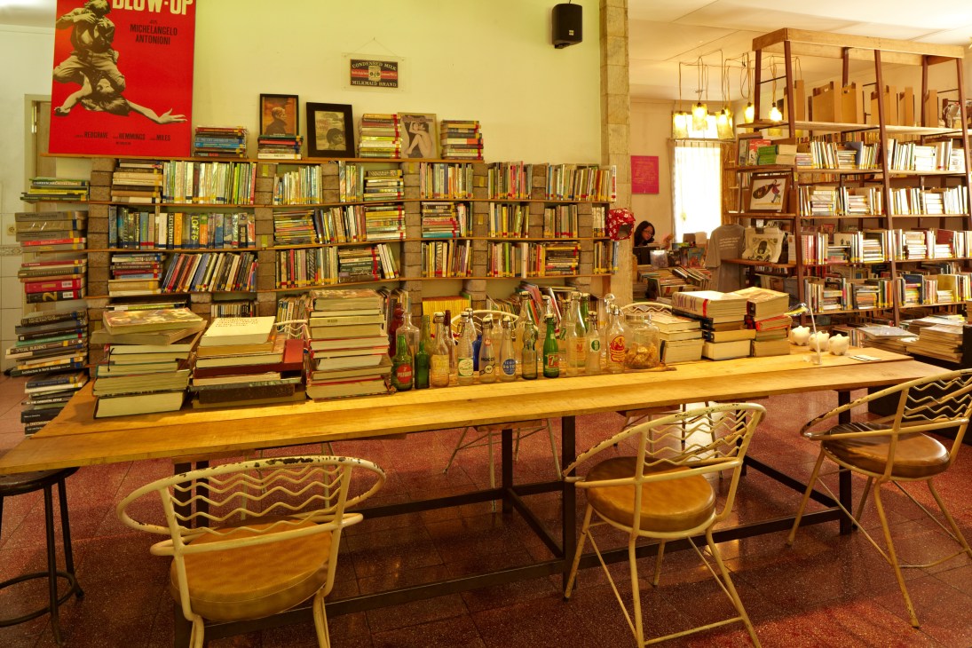 Interior of Kineruku bookshop with shelves of books, wooden tables, and mid-century chairs.