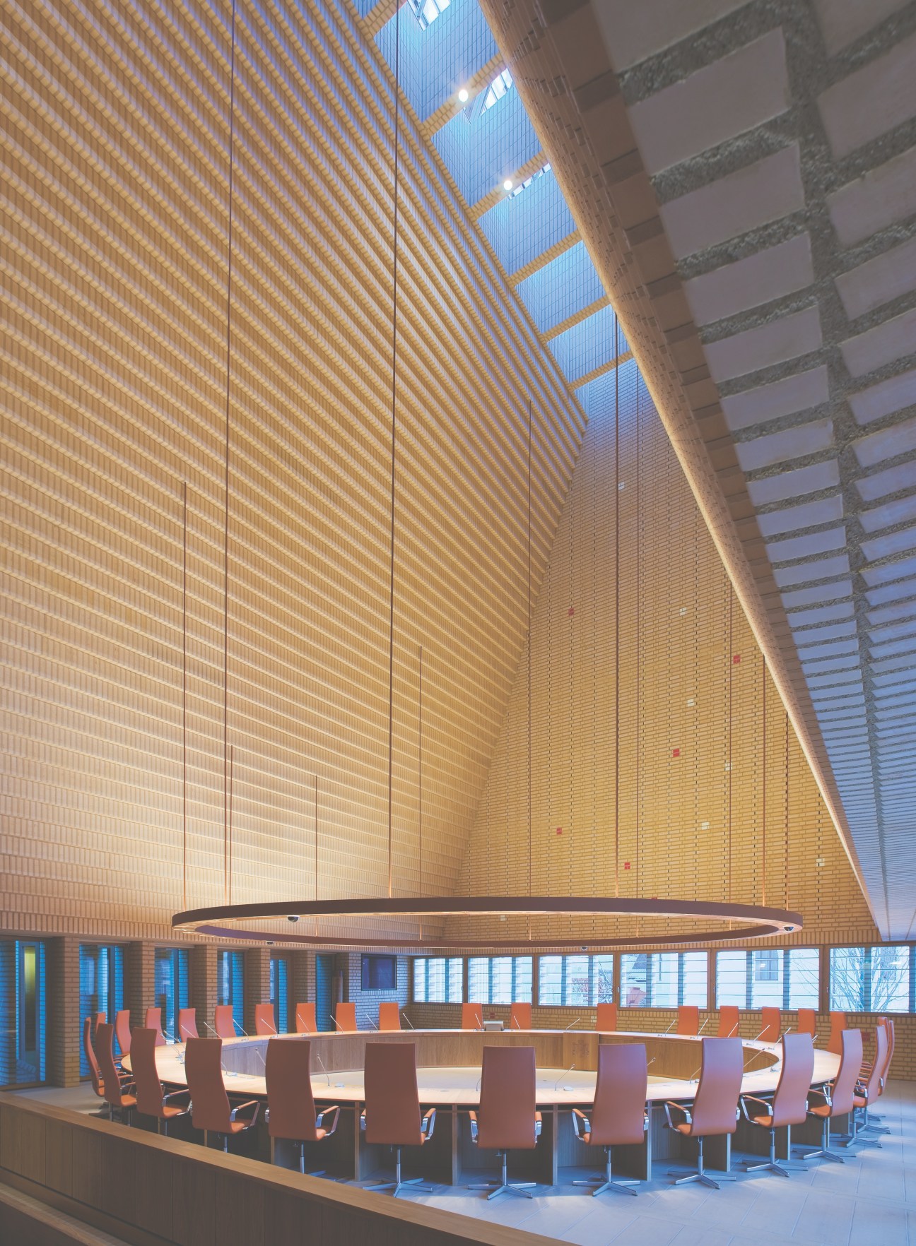Liechtenstein parliament plenary chamber with 25 senators seated in a circular arrangement under a brick barrel vault.