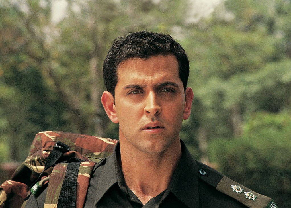 Actor in military uniform from Indian war film Lakshya against forested background.