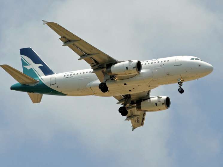 SilkAir commercial aircraft in flight with landing gear down against cloudy sky.