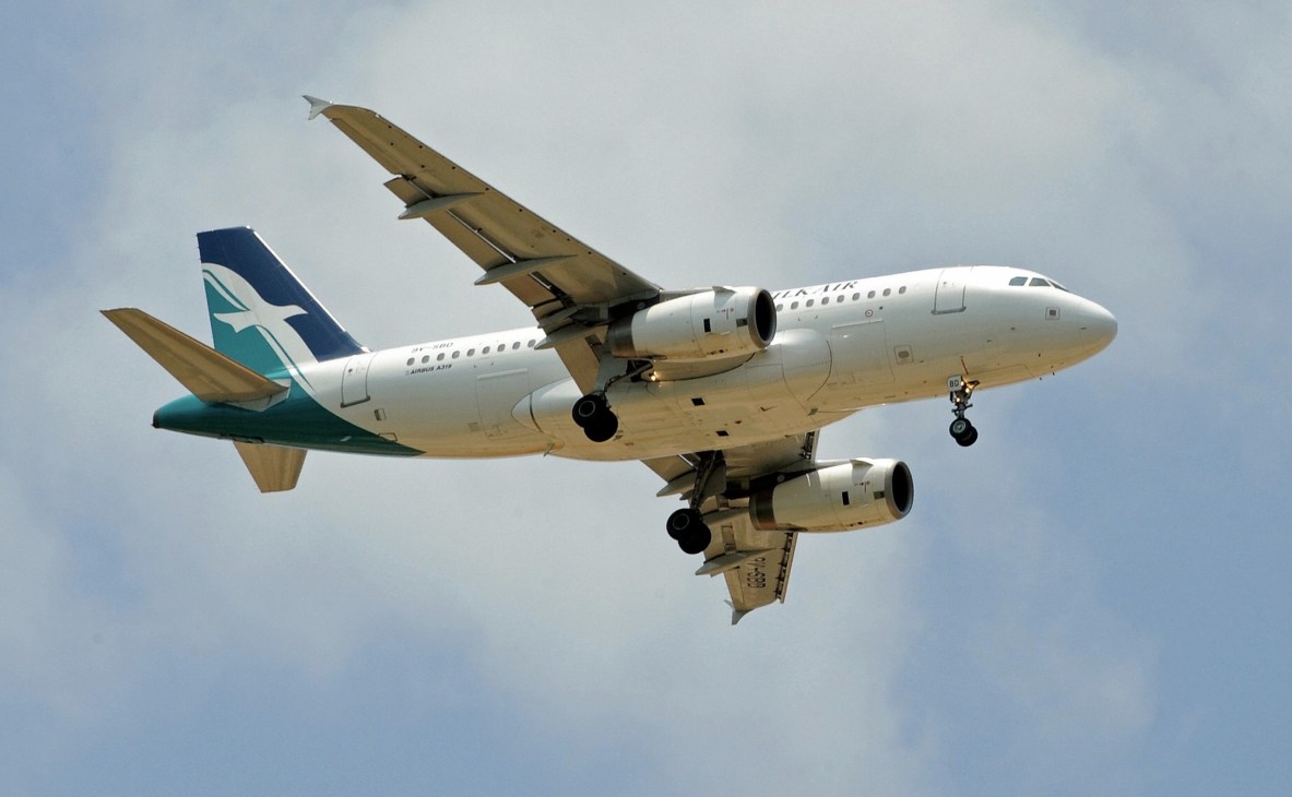 SilkAir commercial aircraft in flight with landing gear down against cloudy sky.