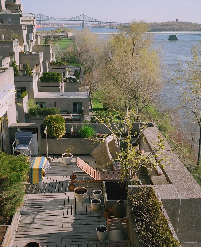 Habitat 67's stacked concrete units with outdoor terraces overlooking the St Lawrence River and bridge in Montreal.