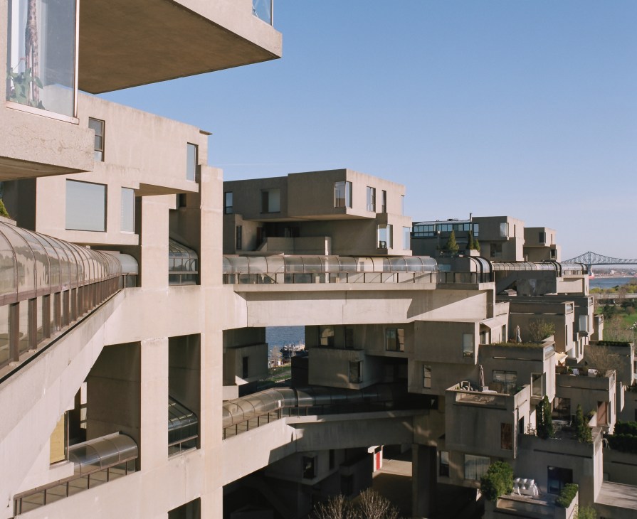 Aerial view of Habitat 67's stacked concrete cube units with connecting walkways and terraces overlooking the St. Lawrence River.
