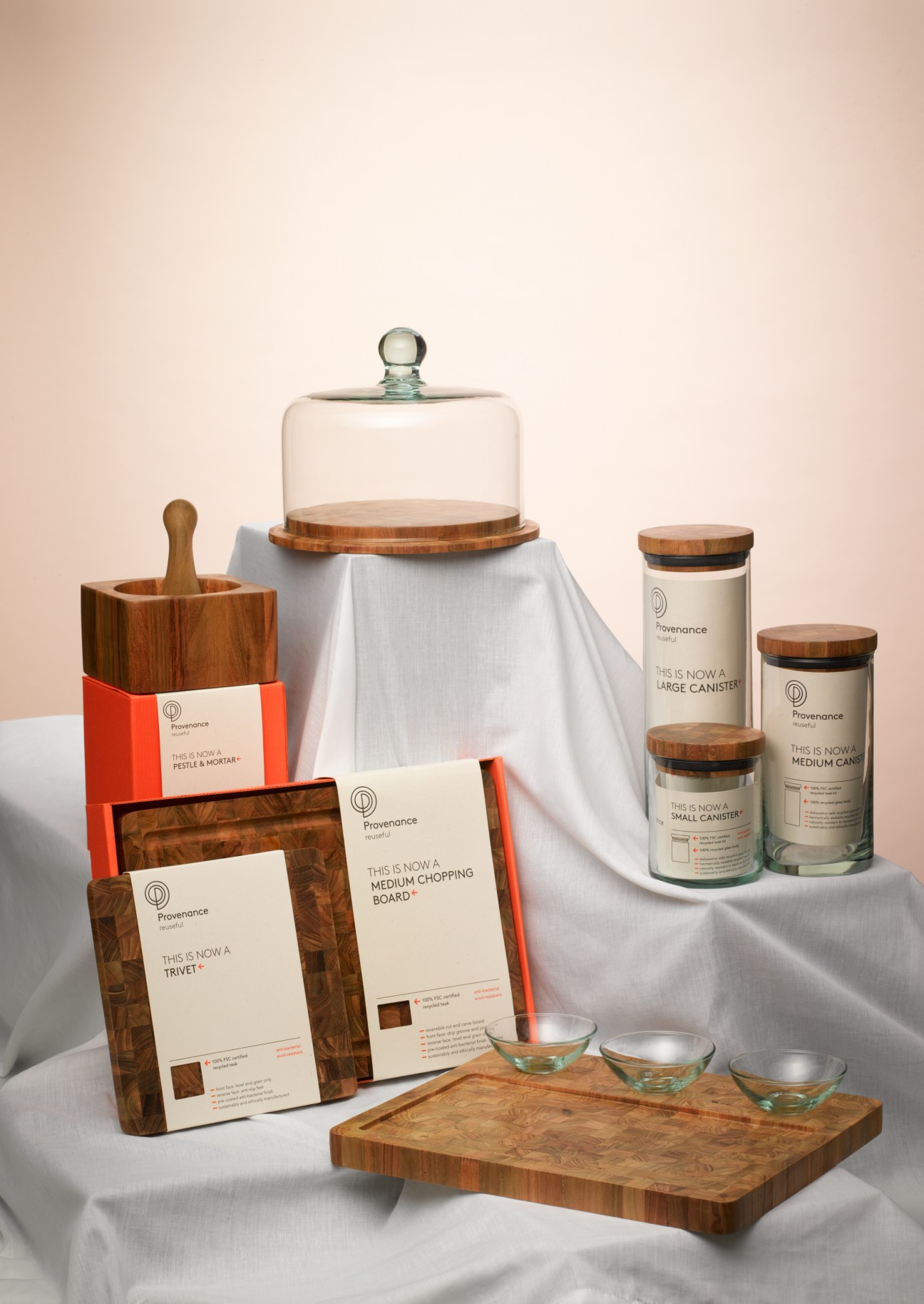 Provenance tableware collection featuring wooden kitchen items, glass cloche, and candles with branded packaging.