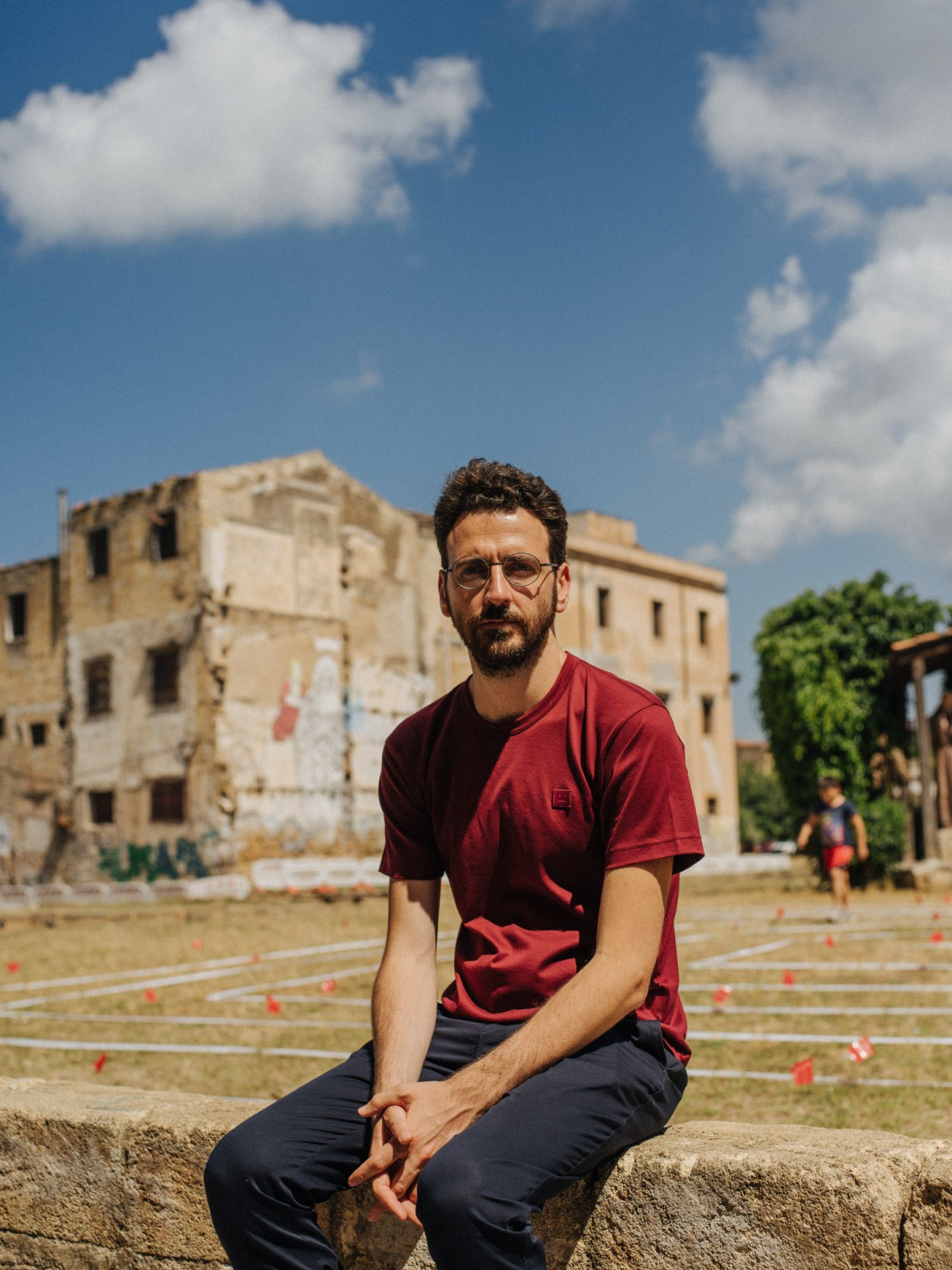 Ippolito Pestellini Laparelli, architect and creative mediator for Manifesta, sits in front of a crumbling palazzo in Palermo.