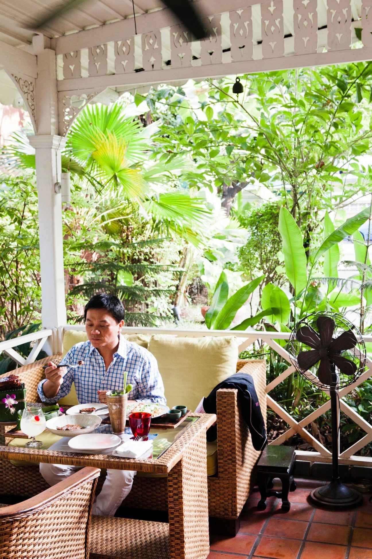Chef Ian Kittichai dining at Issaya Siamese Club with tropical garden visible behind