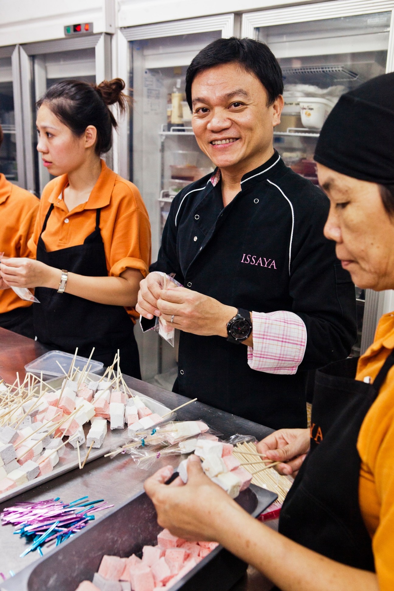 Chef Ian Kittichai smiles while making marshmallow treats with staff in the Issaya kitchen.