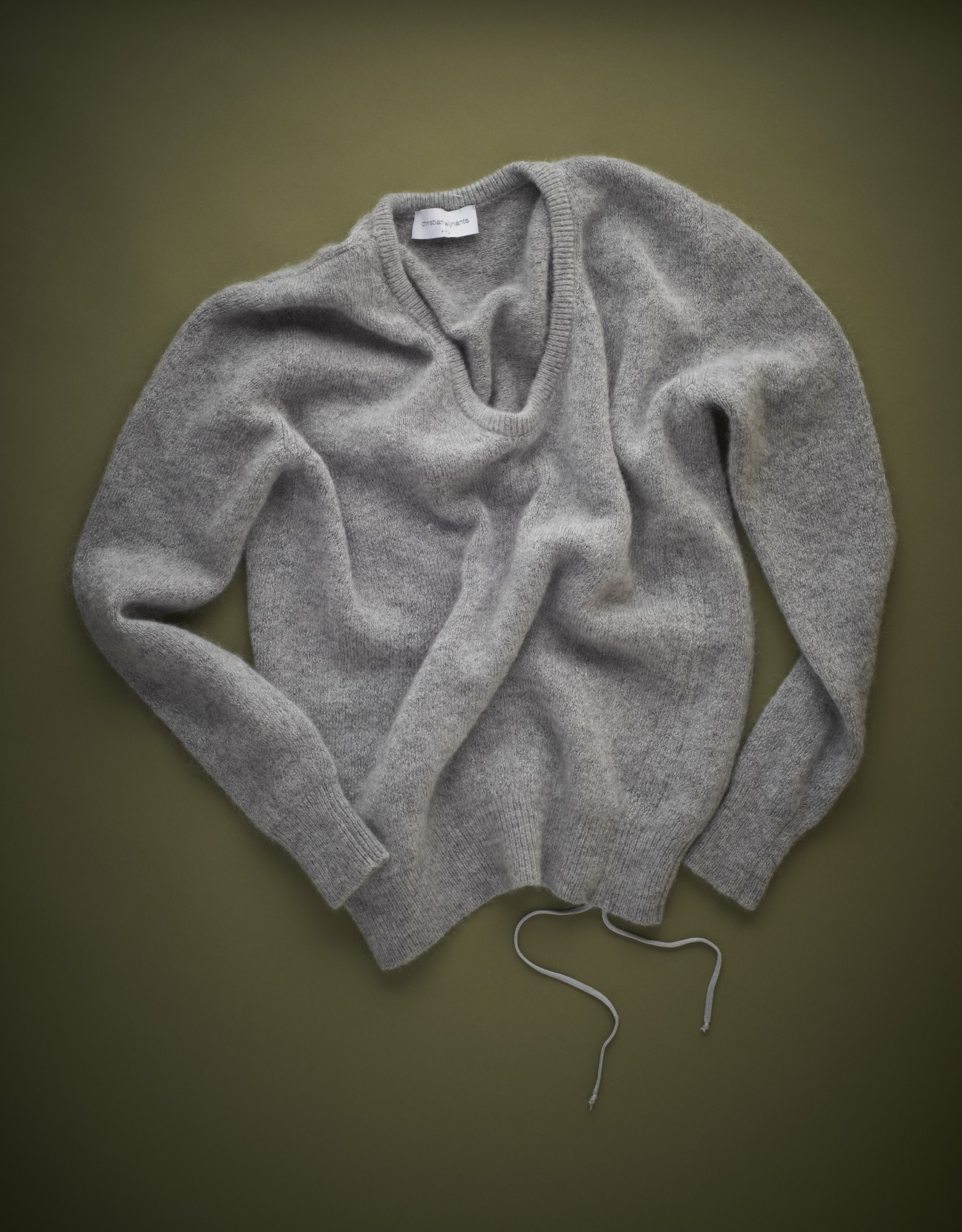 Light gray Merino wool knit sweater with drawstring detail on olive background.