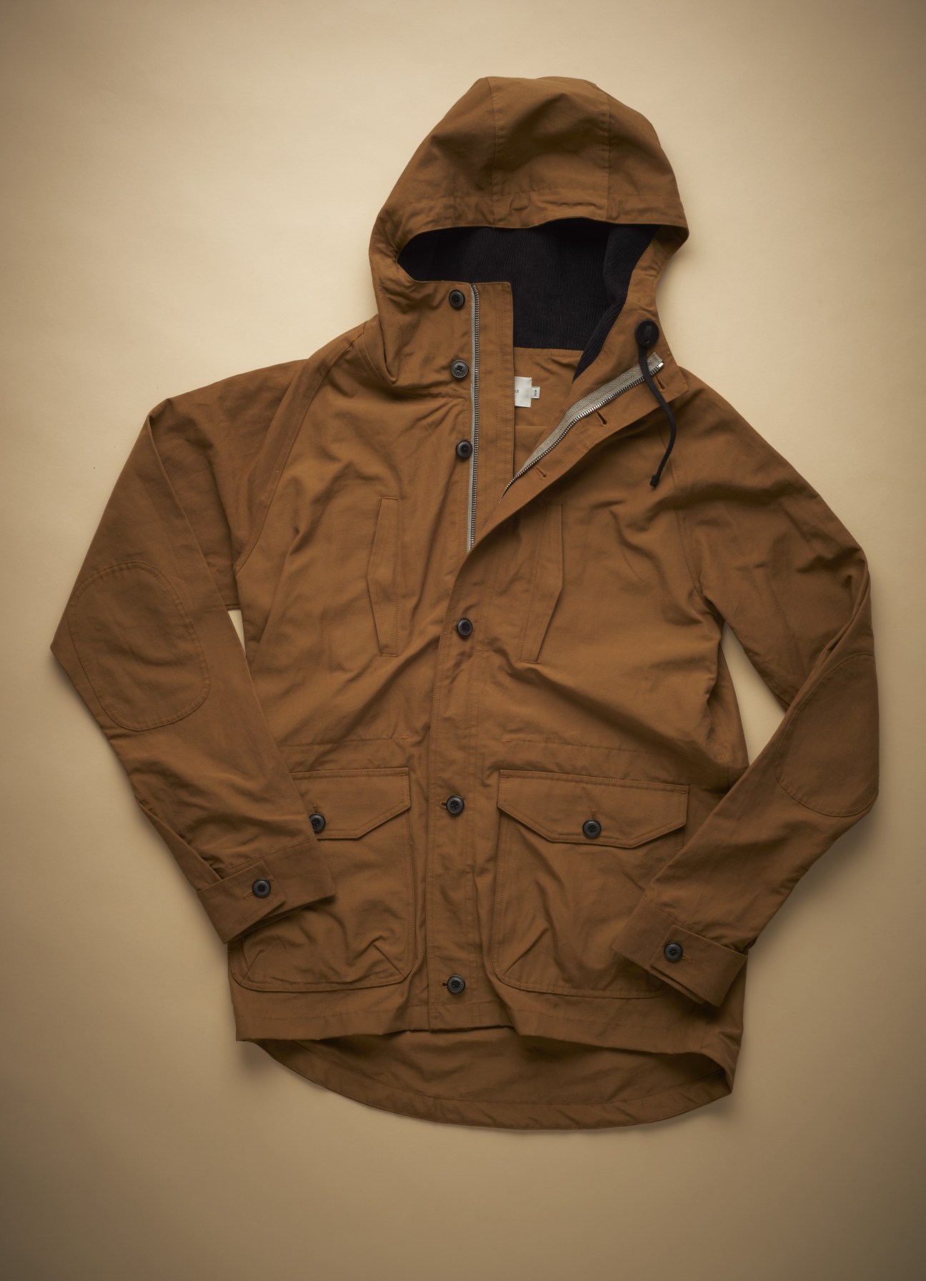 Brown waxed parka with corduroy-lined hood and double zip-front closure by Wings+Horns.