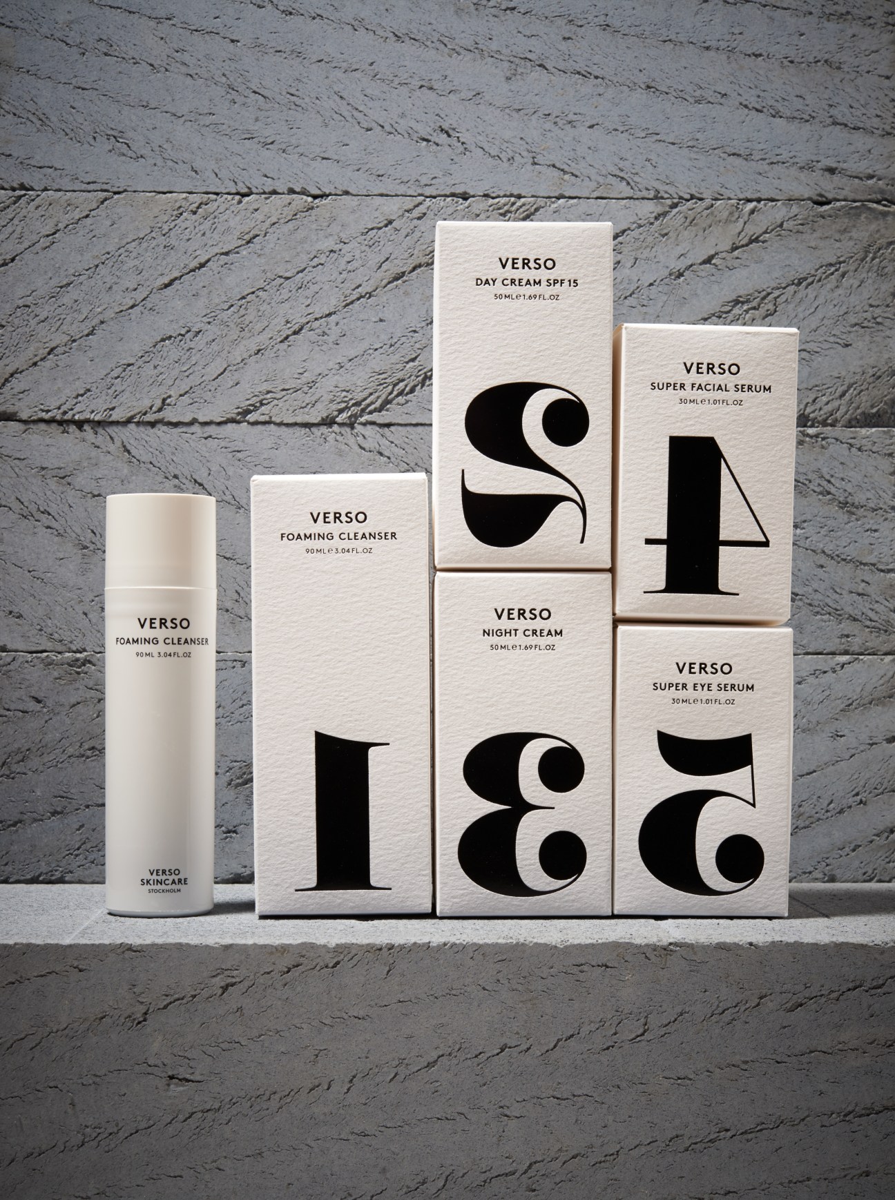 Verso Skincare products arranged on concrete surface, featuring minimalist packaging with bold typography and numerical designs.