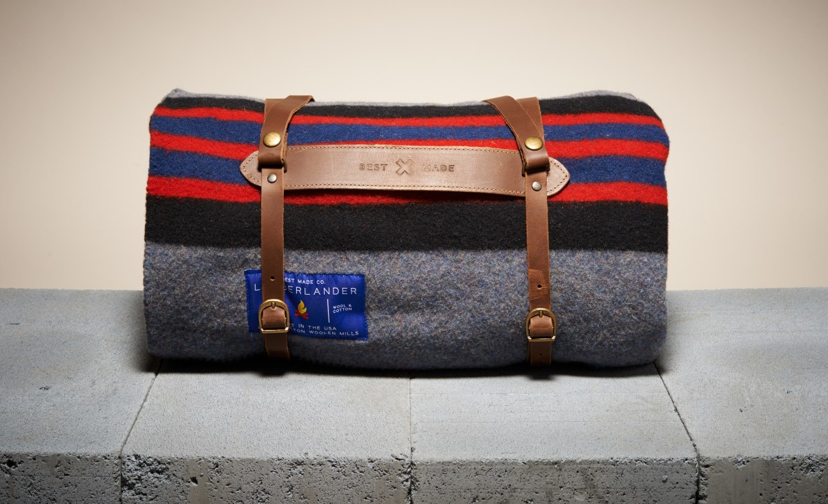 Best Made Lumberland Camp Blanket rolled and secured with brown leather straps and carry handles.