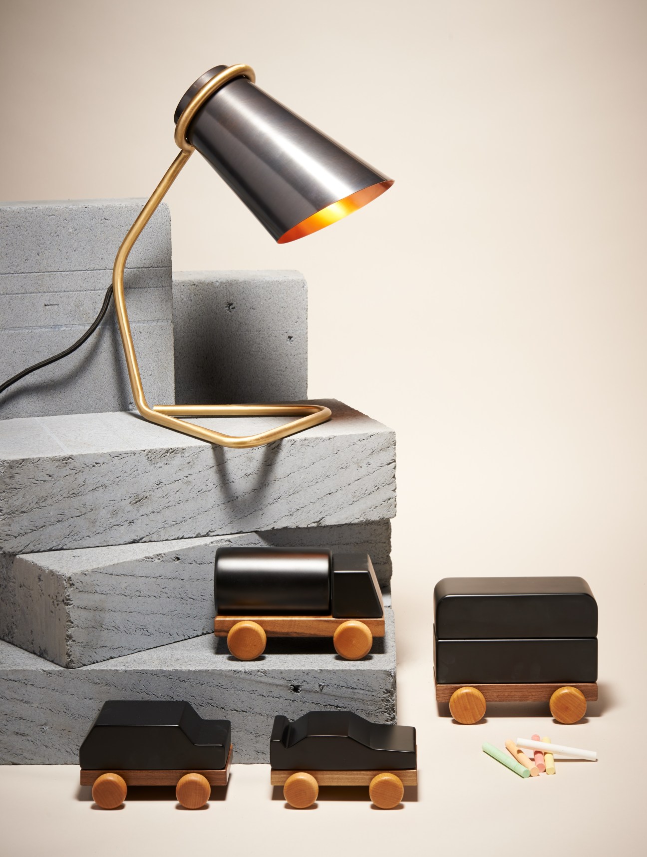 Brass desk lamp with wooden toy cars featuring wooden wheels and walnut bases.