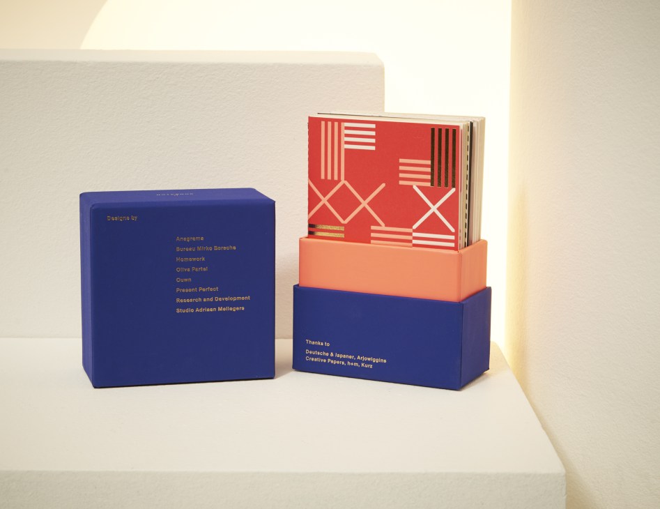 Colorful notebooks with geometric patterns displayed in blue and coral packaging boxes.