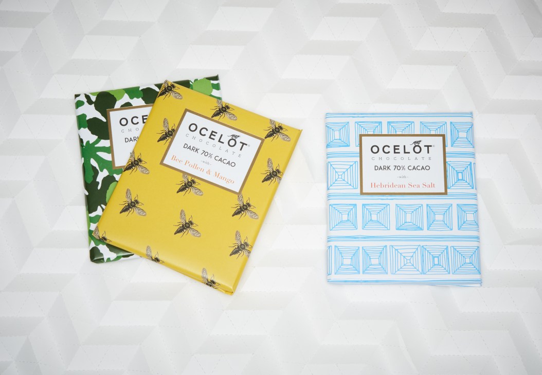 Three Ocelot Chocolate bars with patterned packaging in yellow, green, and blue designs.