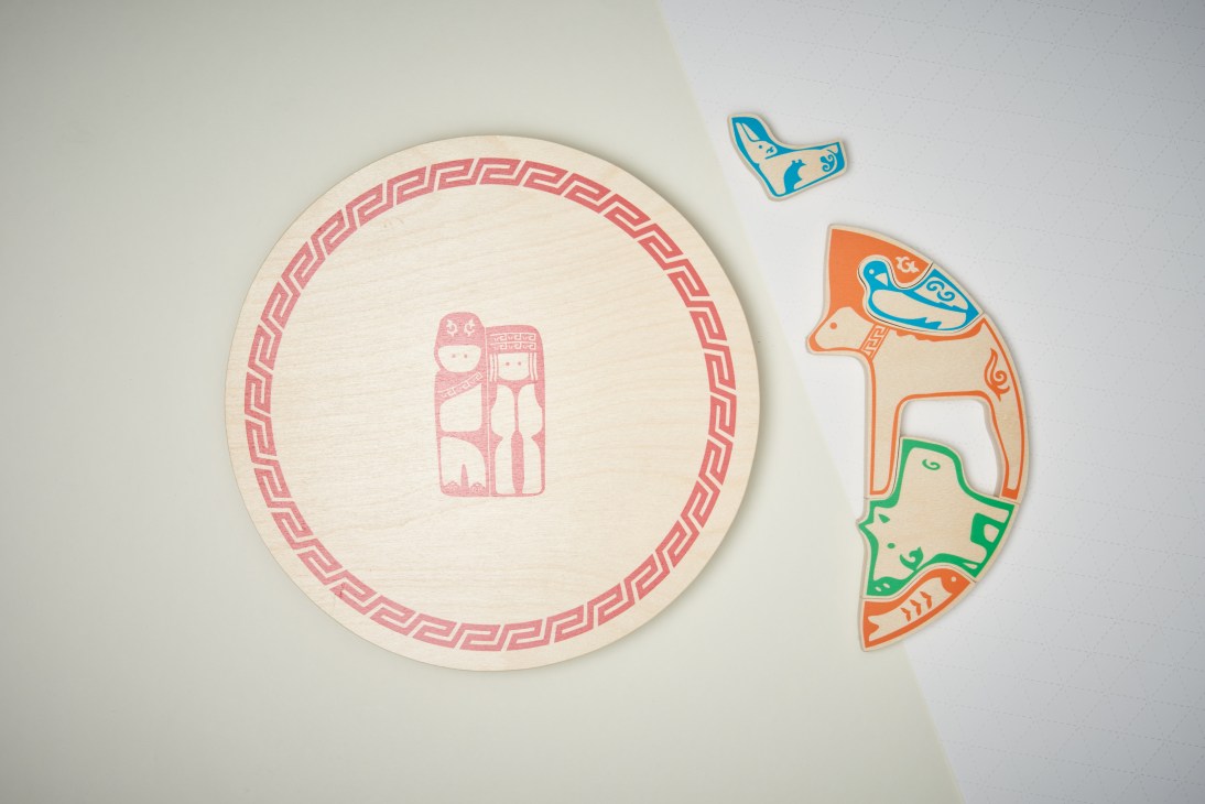 Wooden puzzle by Hayley Ho featuring colorful birch figures representing an Orochen family.