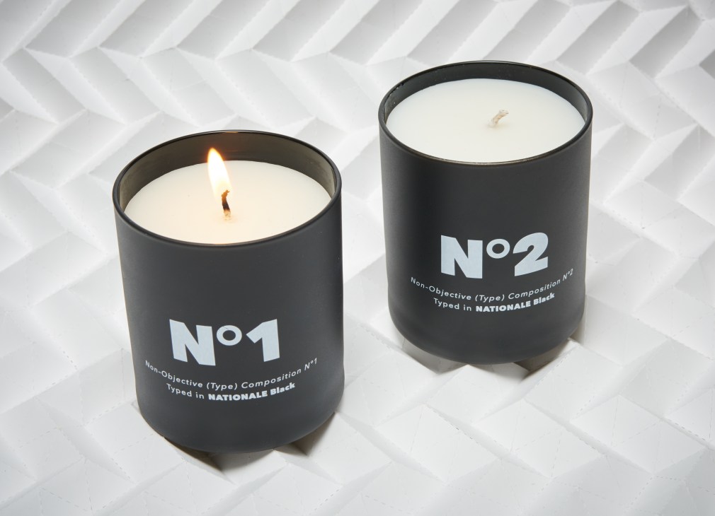 Two black cylindrical candles with white wax and cream-colored labels numbered No.1 and No.2 by Playtype x Skandinavisk.