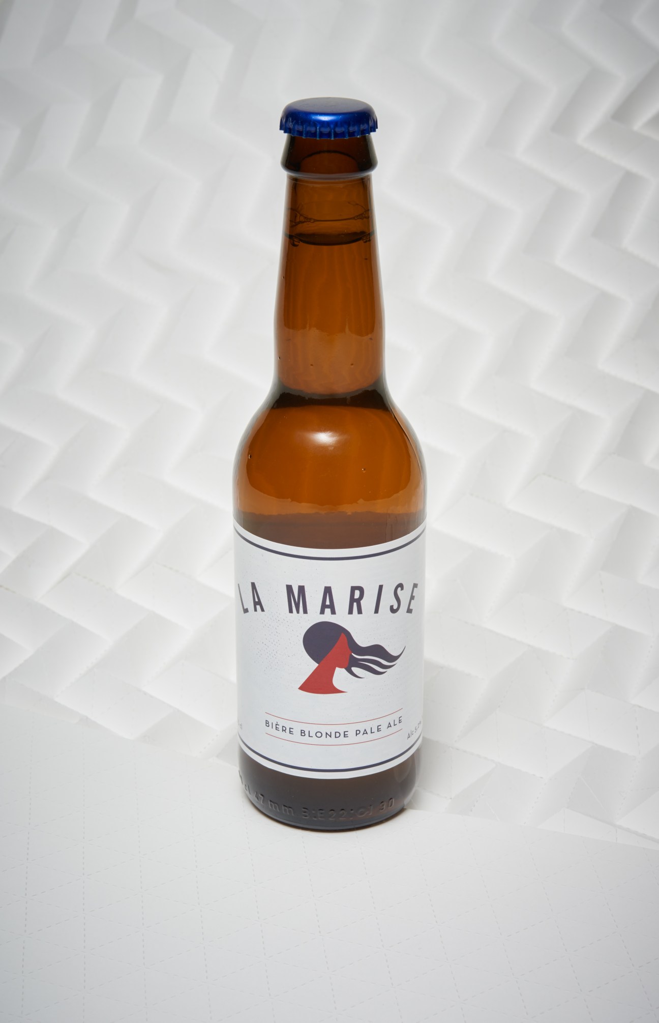 La Marise beer bottle with blue cap and white label featuring a red illustration.