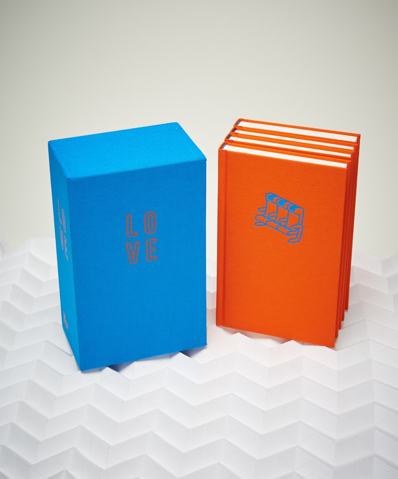 Two colorful books from The School of Life: a blue box-shaped book and an orange stacked book design.