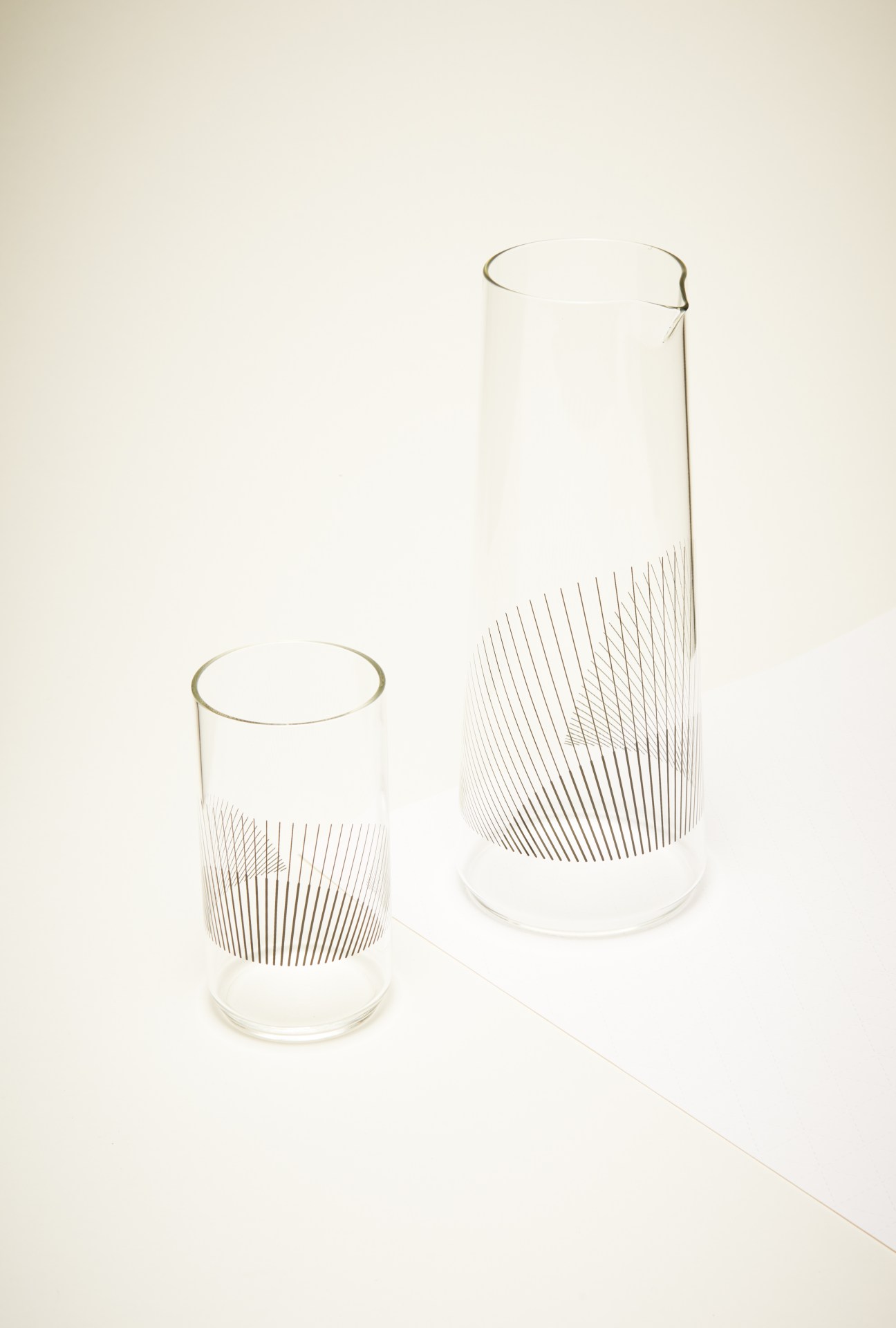 Two clear glasses with linear graphic designs by Liliana Ovalle's Cumulo glassware collection.