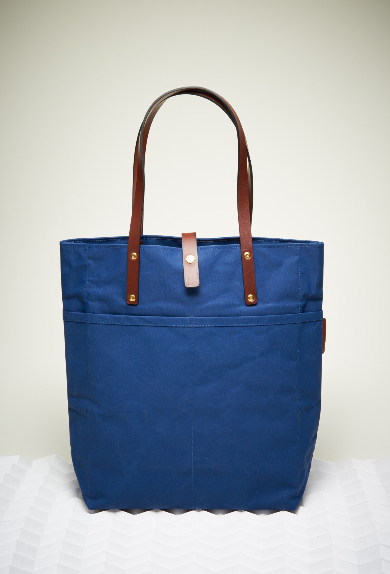 Blue canvas tote bag with brown leather handles and brass rivets by Tailfeather.