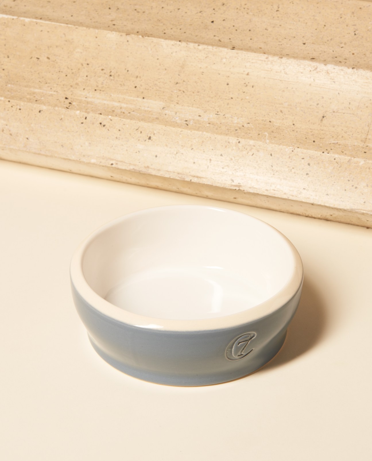 Cloud 7 Jamie dog bowl in grey ceramic with white interior on a cream surface.