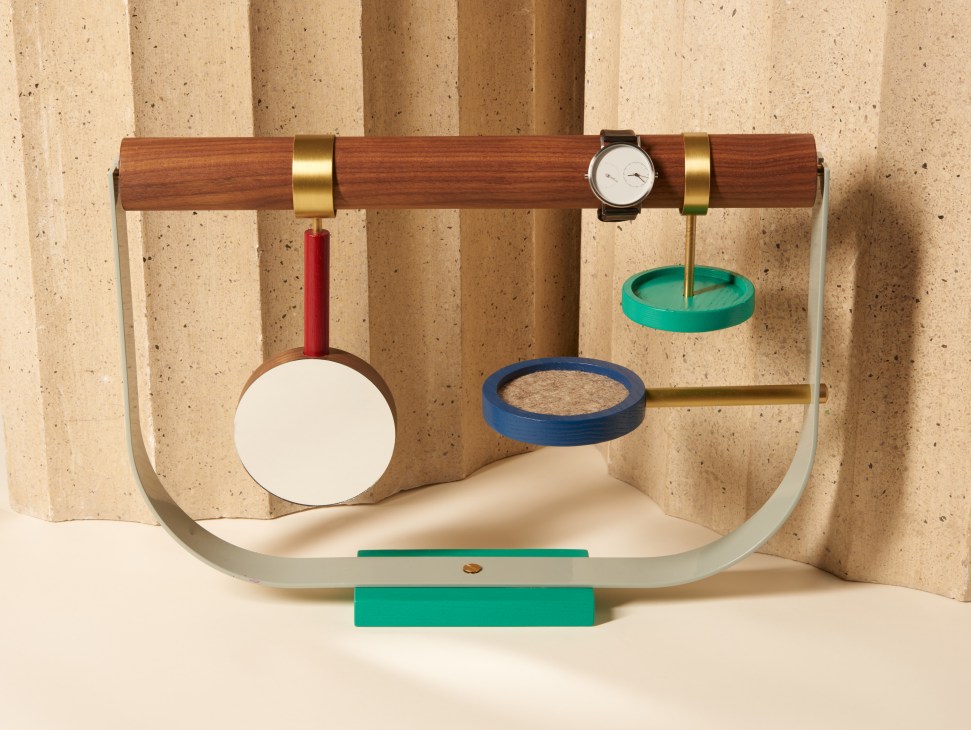 Brass-and-wood jewellery stand by Zoë Mowat with colourful cork-lined rings and a watch.