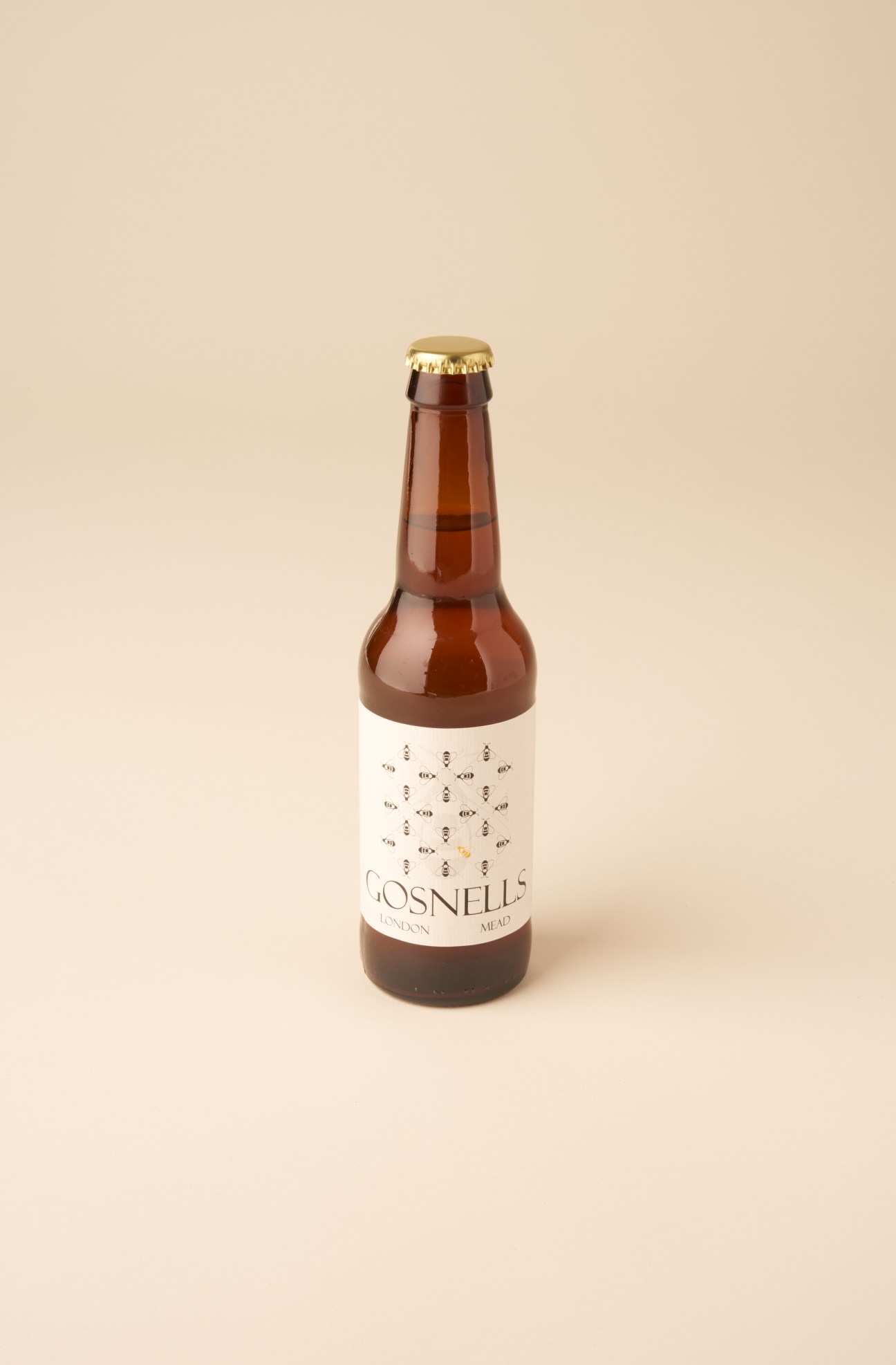 Gosnells London Mead bottle with gold cap and patterned label on beige background.